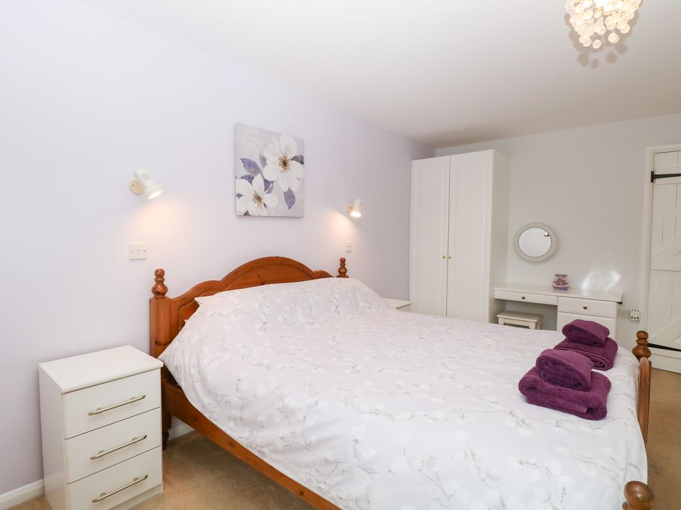 A bedroom with a bed and nightstand at Lowbrook Cottage Dickleburgh near Diss
