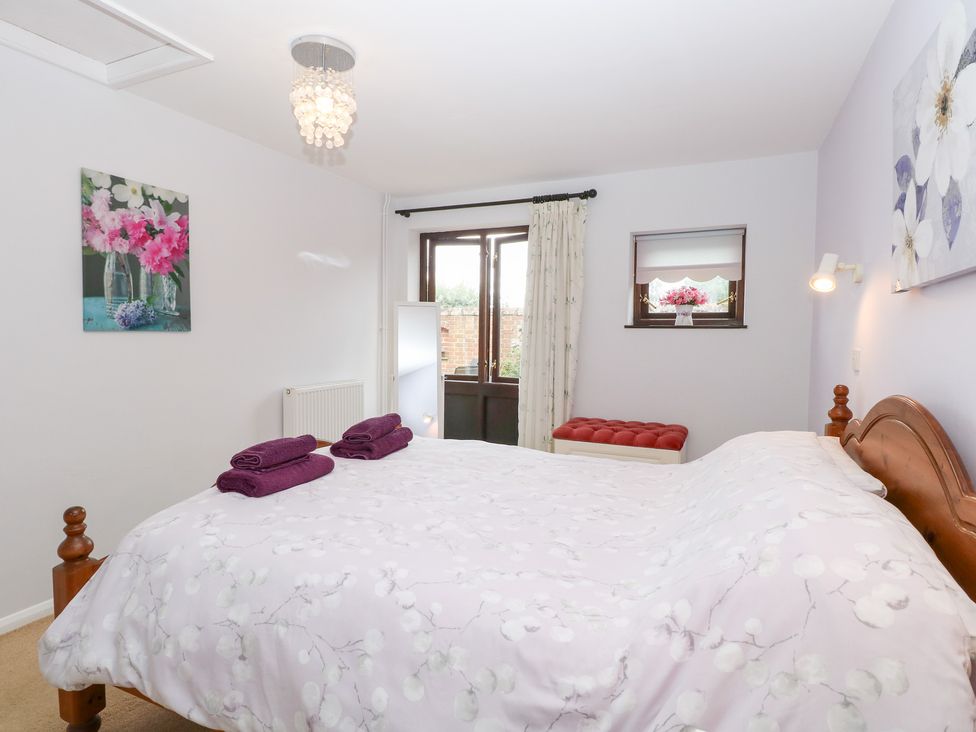 A bedroom with a bed and window at Lowbrook Cottage Dickleburgh near Diss