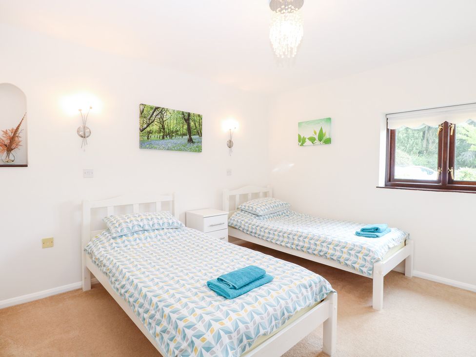A bedroom with two beds and a window at Lowbrook Cottage in Dickleburgh near Diss