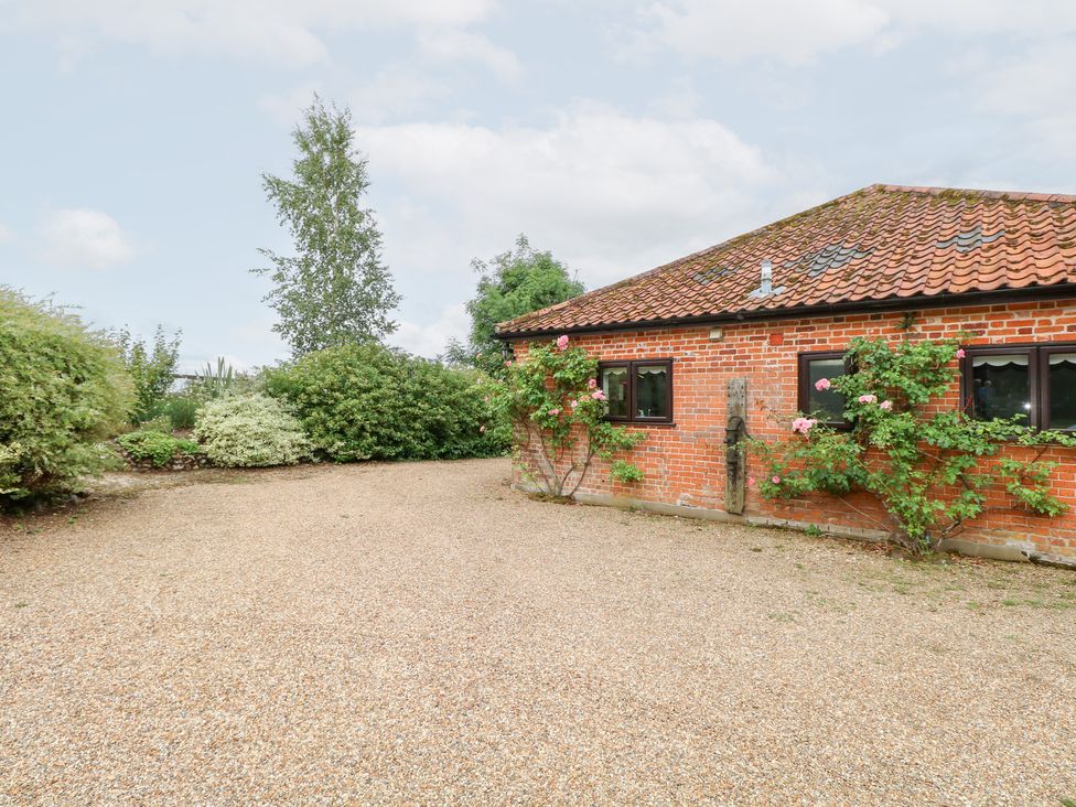 An outdoor area with a brick wall and gravel surface at Lowbrook Cottage Dickleburgh near Diss
