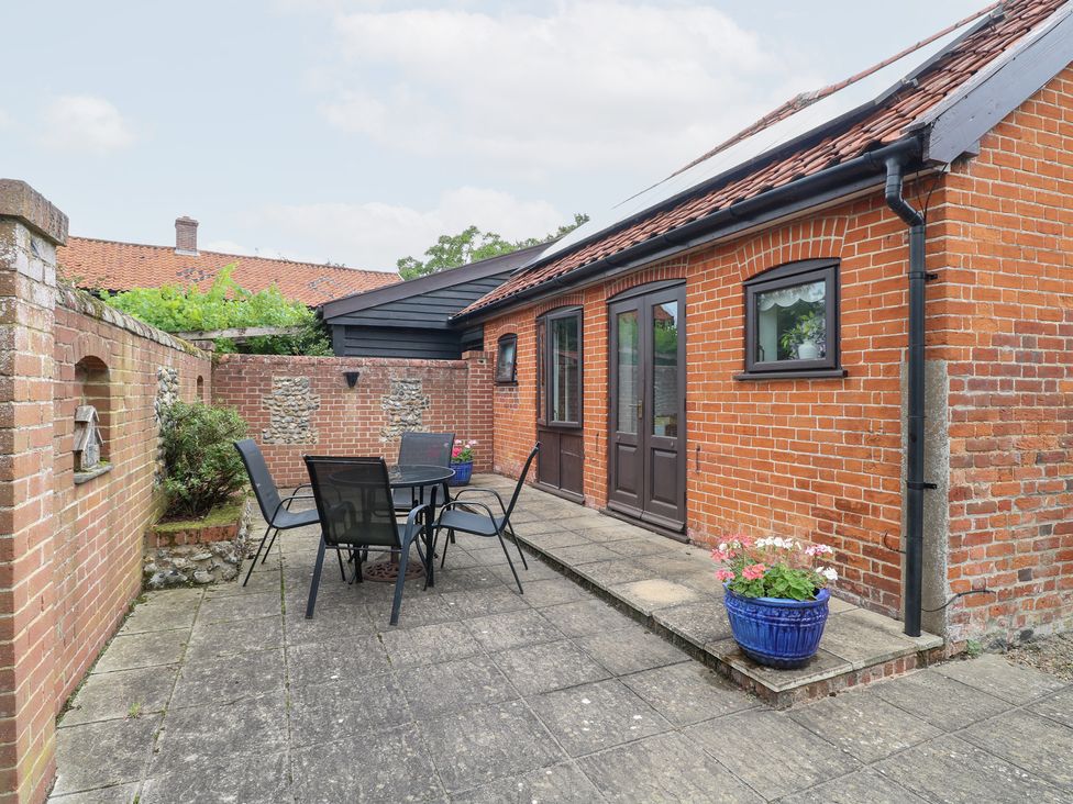 An outdoor patio area with a table and chairs at Lowbrook Cottage in Dickleburgh near Diss