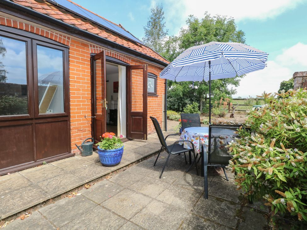 An outdoor seating area with a table and chairs at Lowbrook Cottage Dickleburgh near Diss