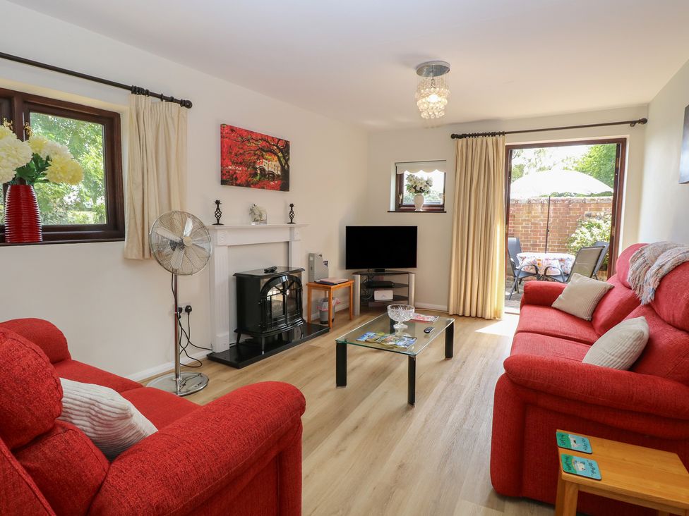 A living room with a sofa and television at Lowbrook Cottage Dickleburgh near Diss