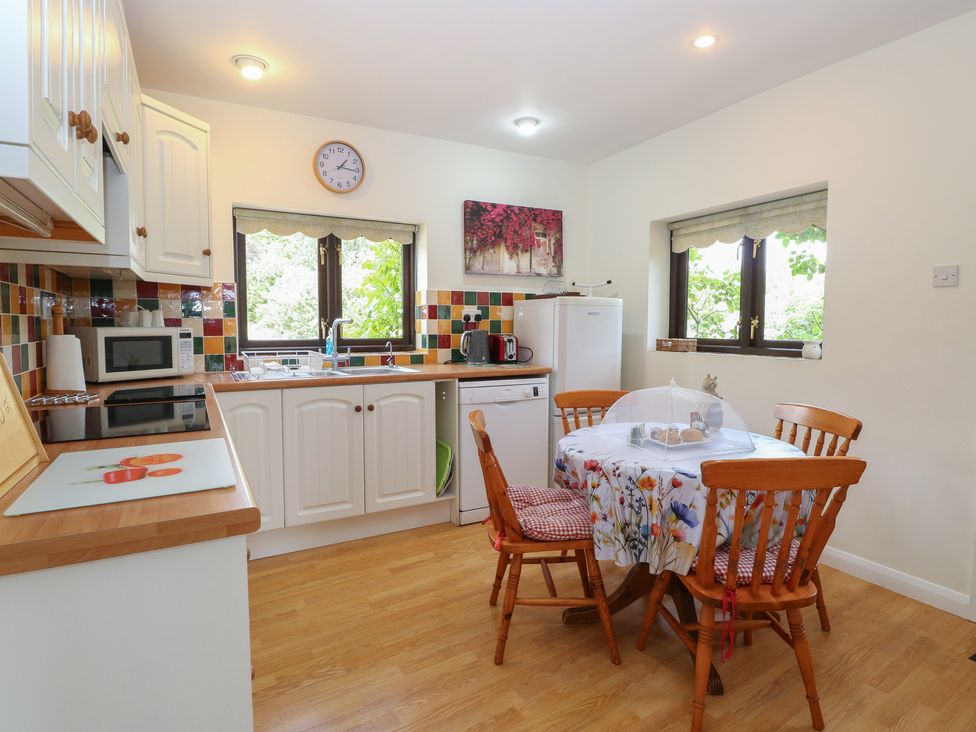 A kitchen with a table and chairs at Lowbrook Cottage in Dickleburgh near Diss
