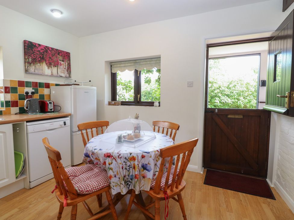 A kitchen with a table and chairs at Lowbrook Cottage in Dickleburgh near Diss