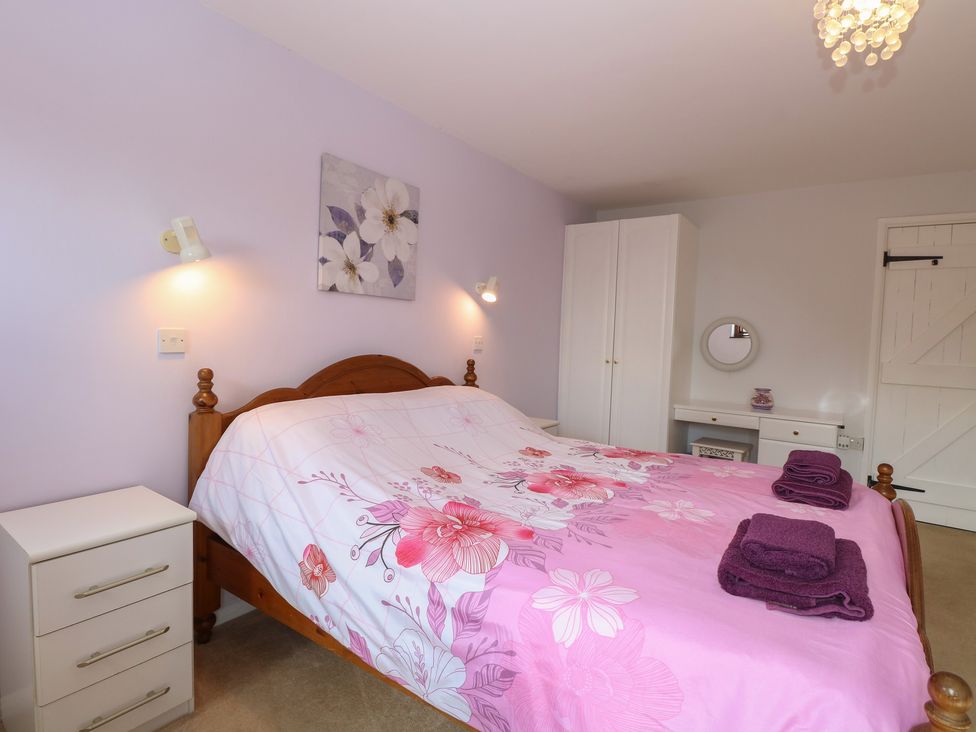 A bedroom with a bed and furniture at Lowbrook Cottage in Dickleburgh near Diss