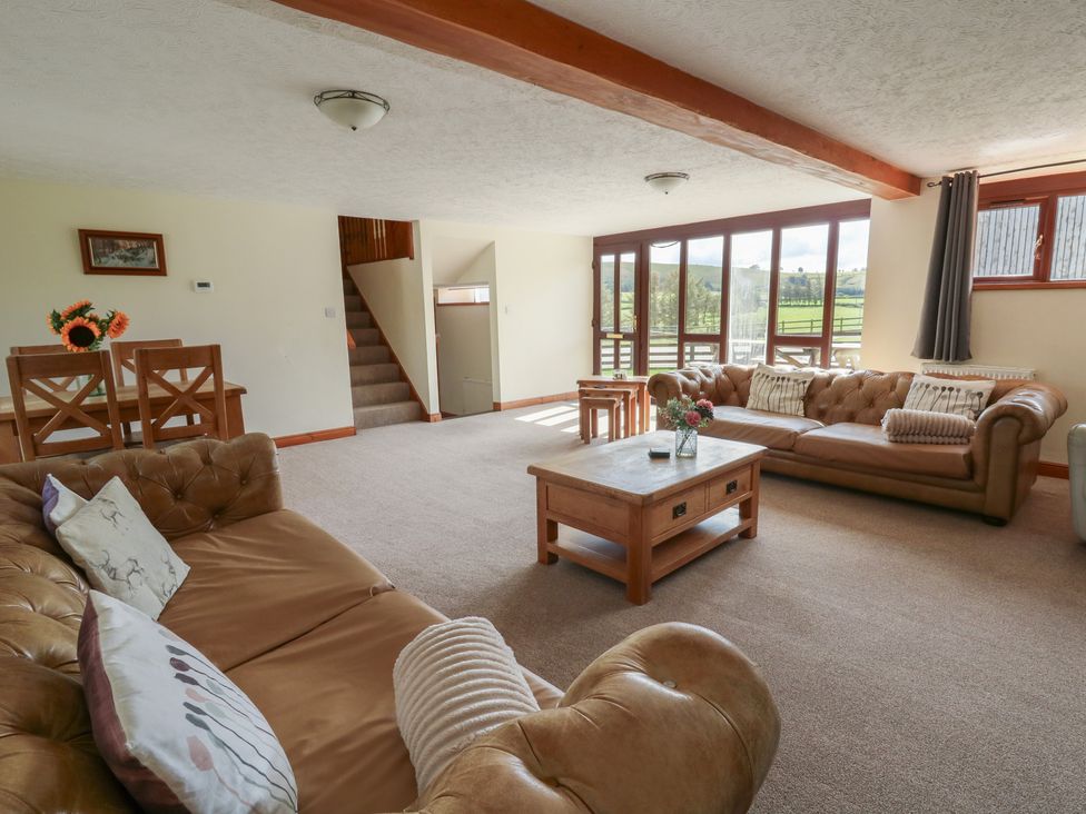 A living room with seating and a dining area at Glanyrafon St Harmon