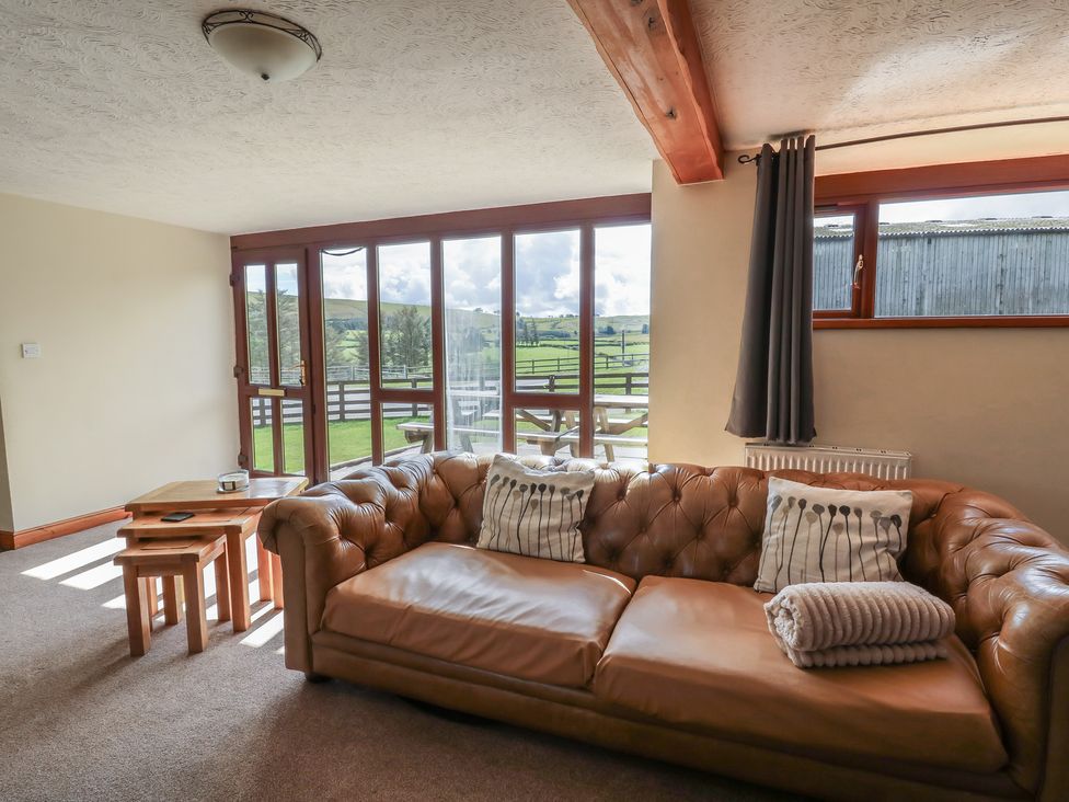 A living room with a sofa and coffee table at Glanyrafon in St Harmon