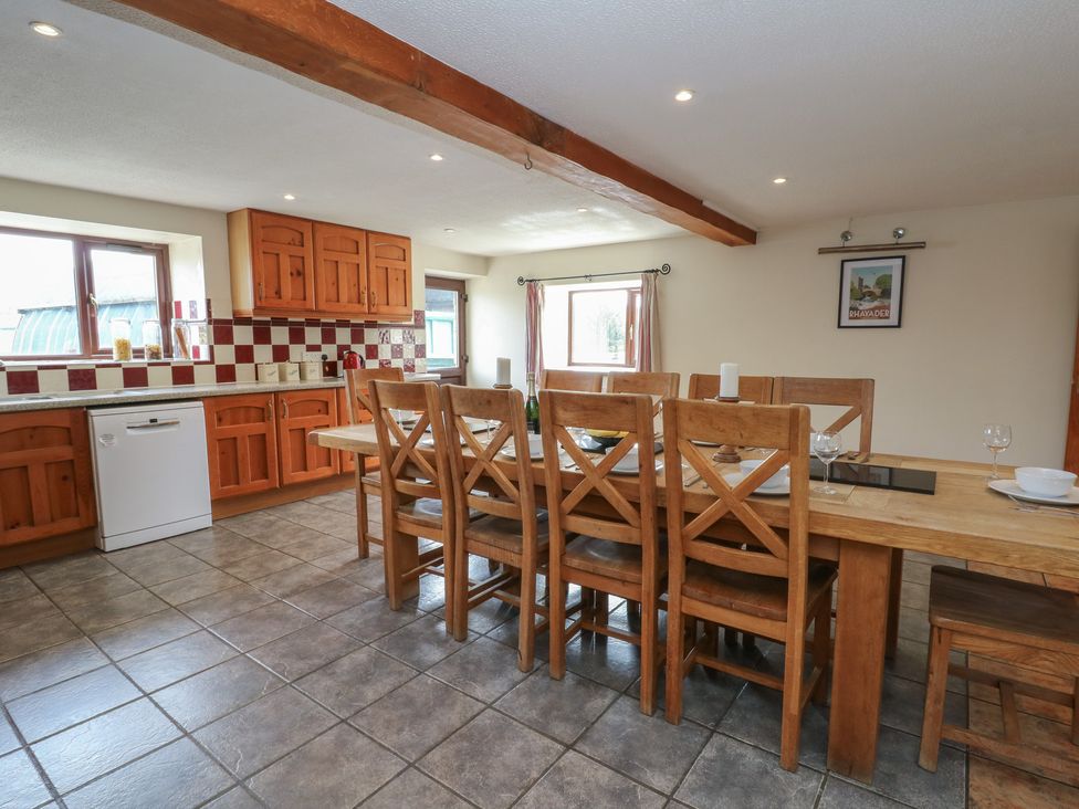 A kitchen with a dining table and chairs at Glanyrafon in St Harmon