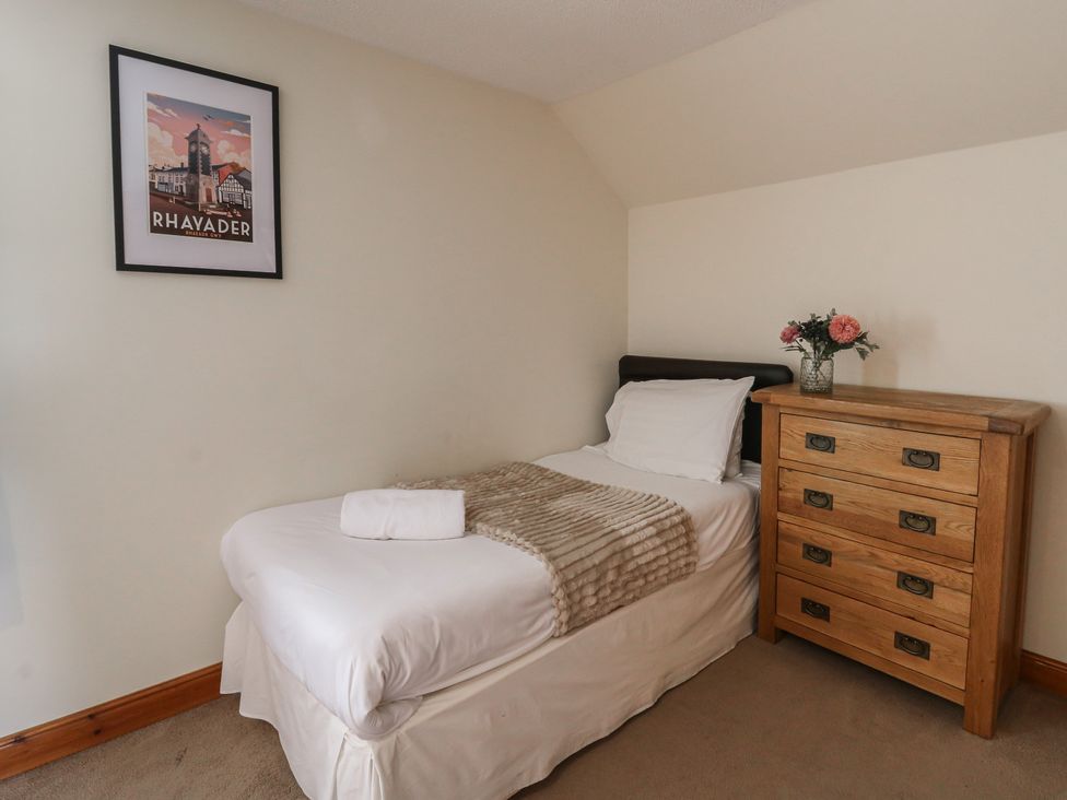 A bedroom with a single bed and a chest of drawers at Glanyrafon in St Harmon
