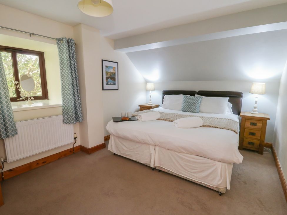 A bedroom with a bed and window at Glanyrafon in St Harmon