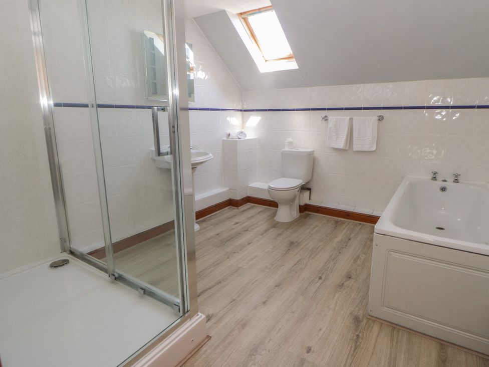 A bathroom with a shower, toilet, sink, and bathtub at Glanyrafon in St Harmon