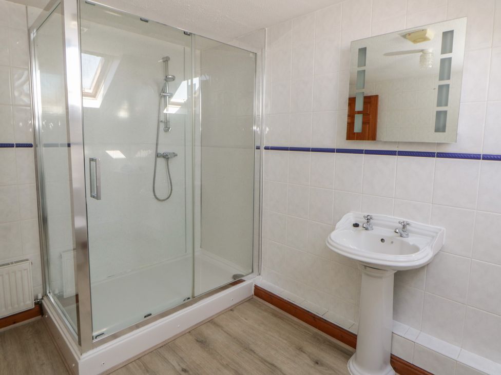 A bathroom with a shower and a sink at Glanyrafon St Harmon