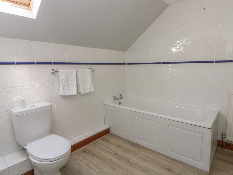 A bathroom with a bathtub and a toilet at Glanyrafon St Harmon