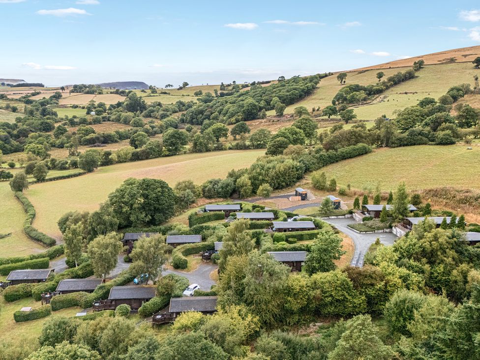 An aerial view of wooden cabins in a rural area at Glanyrafon Bungalow St Harmon