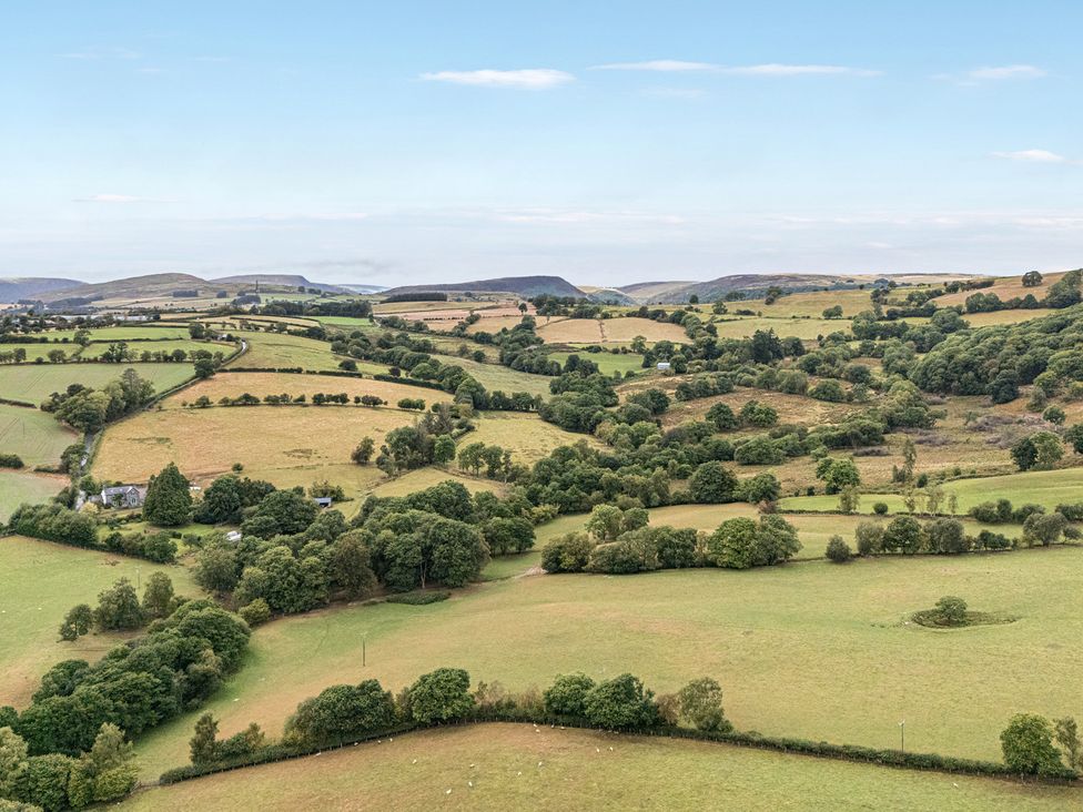 A landscape view with fields and trees at Glanyrafon Bungalow in St Harmon