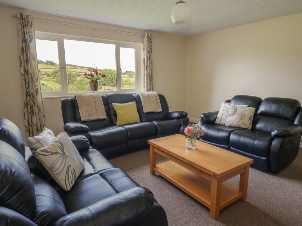 A living room with sofas and a coffee table at Glanyrafon Bungalow St Harmon