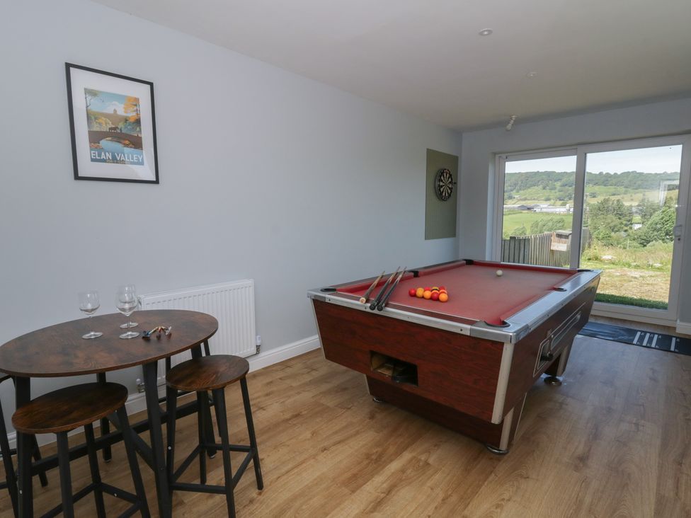 A game room with a pool table and a table with chairs at Glanyrafon Bungalow in St Harmon