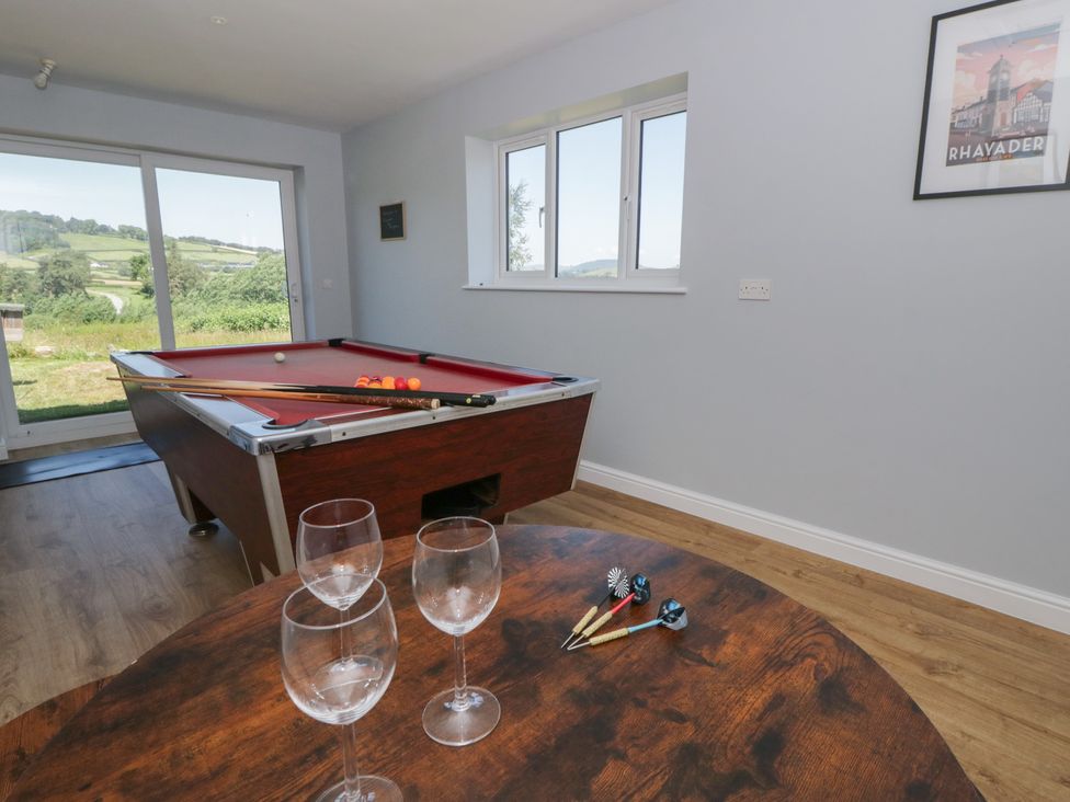 A snug with a pool table and wine glasses at Glanyrafon Bungalow in St Harmon