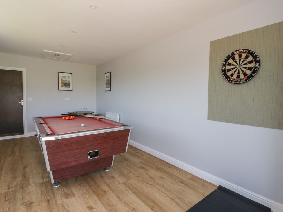 A game room with a pool table and a dartboard at Glanyrafon Bungalow St Harmon