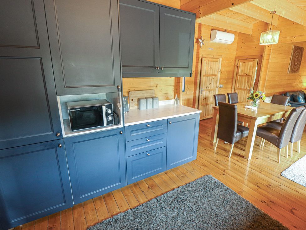 A kitchen with cabinets and a dining area at Tythe Lodge – Hot Tub Retreat in Rural Lincolnshire | Family-Friendly Lodge Near Heckington