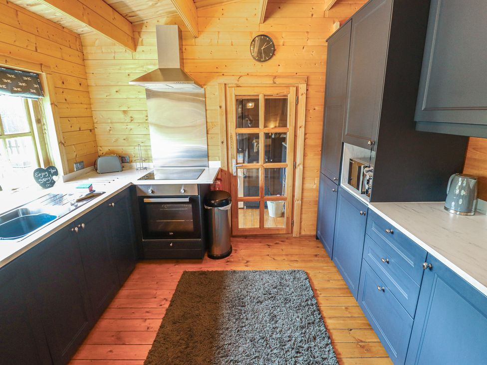 A kitchen with cabinets and appliances at Tythe Lodge – Hot Tub Retreat in Rural Lincolnshire | Family-Friendly Lodge Near Heckington