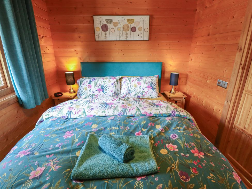 A bedroom with a bed and bedside lamps at Tythe Lodge – Hot Tub Retreat in Rural Lincolnshire | Family-Friendly Lodge Near Heckington