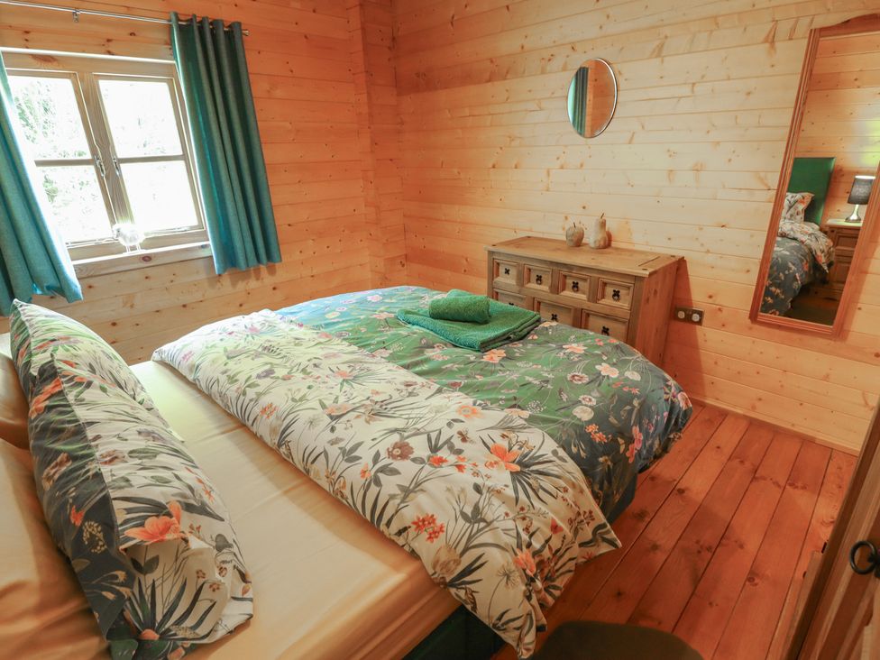 A bedroom with a bed and window at Tythe Lodge – Hot Tub Retreat in Rural Lincolnshire | Family-Friendly Lodge Near Heckington