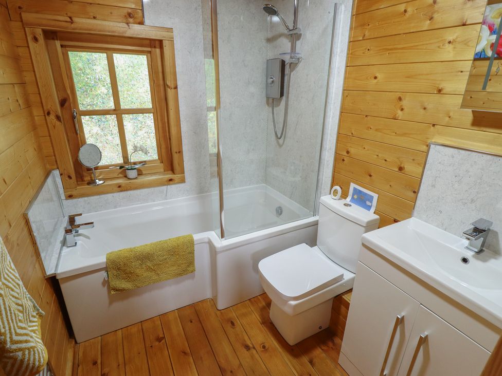 A bathroom with a bathtub, shower, sink, and toilet at Tythe Lodge – Hot Tub Retreat in Rural Lincolnshire | Family-Friendly Lodge Near Heckington