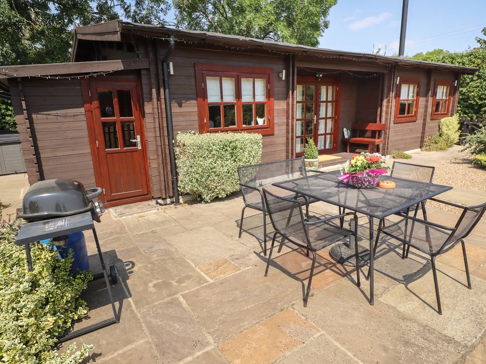 An outdoor area with a table and chairs at Tythe Lodge – Hot Tub Retreat in Rural Lincolnshire | Family-Friendly Lodge Near Heckington