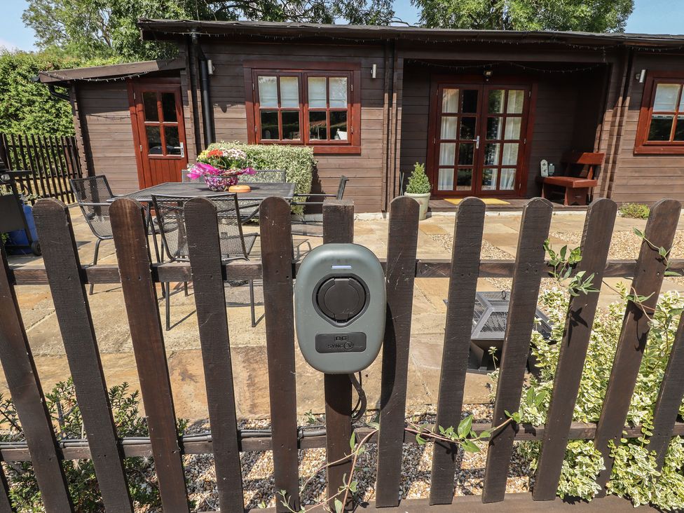 An outdoor area with a table and chairs at Tythe Lodge – Hot Tub Retreat in Rural Lincolnshire | Family-Friendly Lodge Near Heckington