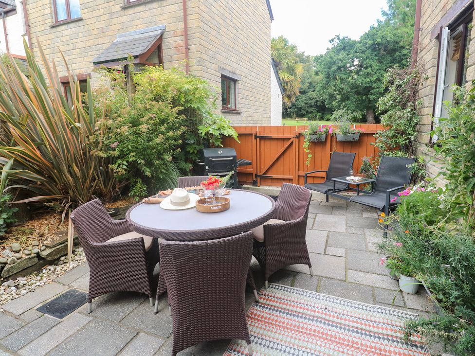 A garden with a dining table and chairs at Tranquility in Falmouth