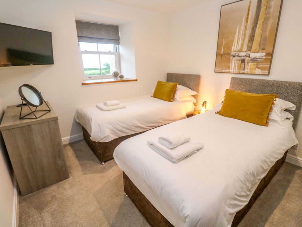 A bedroom with two beds, a television, and a window at Silvermine House in Charlestown