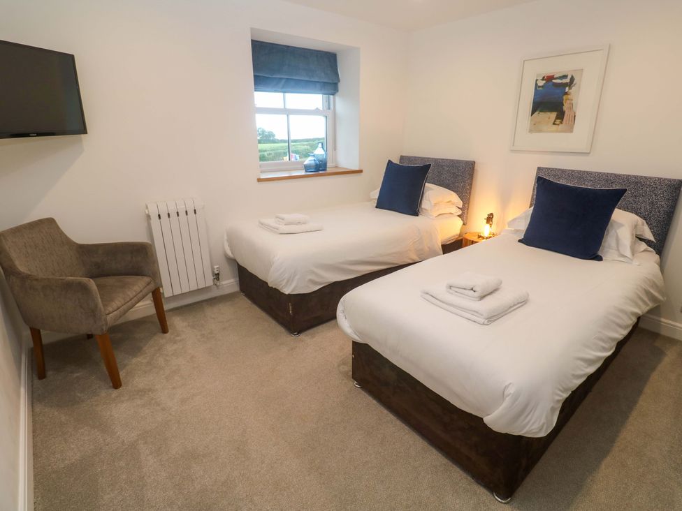 A bedroom with two beds and an armchair at Silvermine House in Charlestown