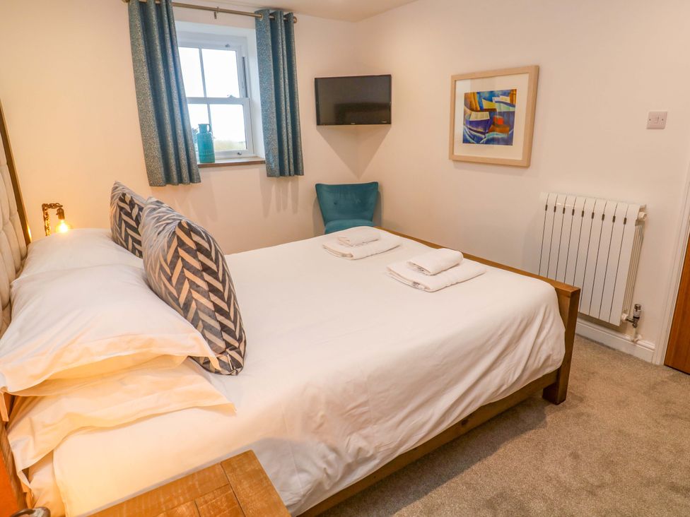 A bedroom with a bed, television, and window at Silvermine House Charlestown