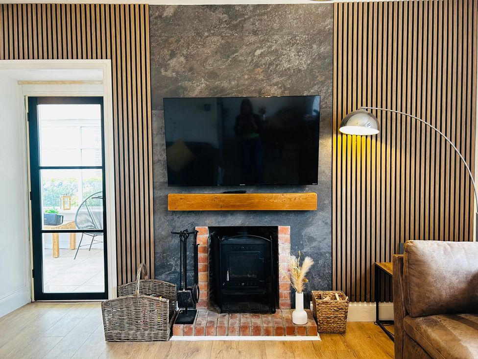 A living room with a television and a fireplace at Trearddur View in Treaddur Bay