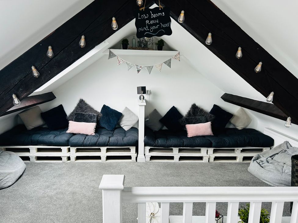 A snug with seating area and hanging lights at Trearddur View in Treaddur Bay