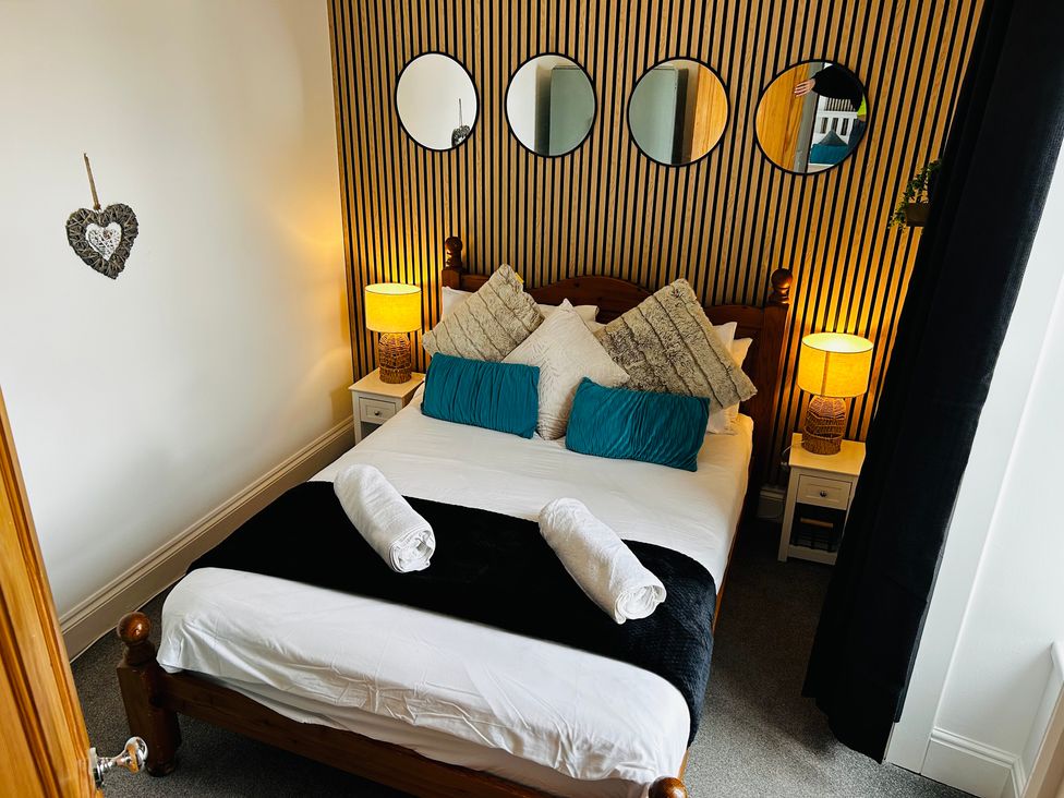 A bedroom with a bed and lamps at Trearddur View in Treaddur Bay
