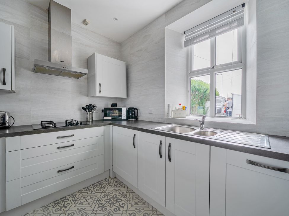 A kitchen with a sink and stove at Trearddur View in Treaddur Bay