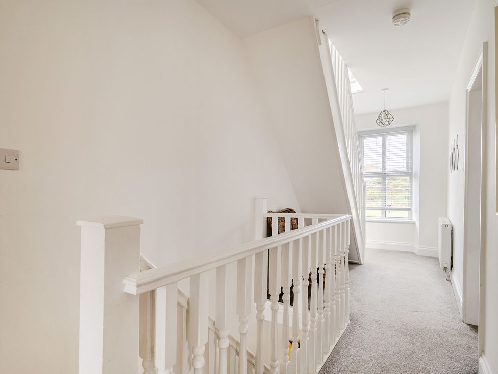 A hallway with a staircase and window at Trearddur View in Treaddur Bay