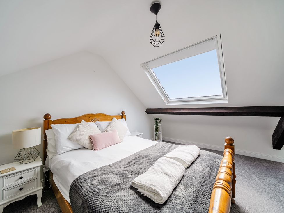 A bedroom with a bed and window at Trearddur View in Treaddur Bay