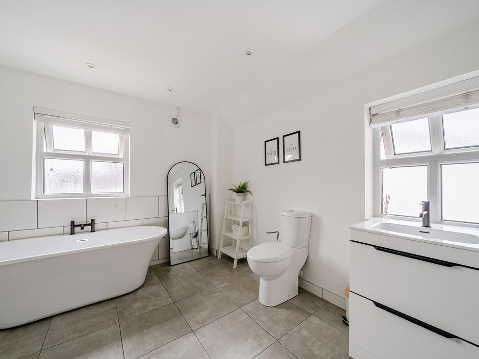 A bathroom with a bathtub, toilet and sink at Trearddur View in Treaddur Bay