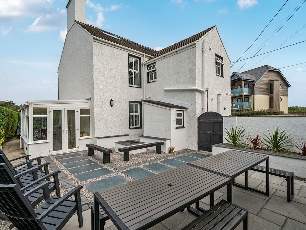 A garden with a table and chairs outside the house at Trearddur View, Treaddur Bay