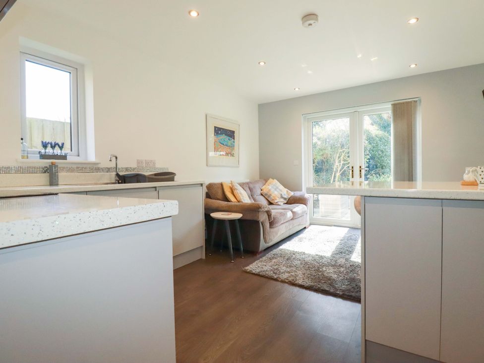 A kitchen with a sofa and coffee table at Little Pippin Carlyon Bay near St Austell