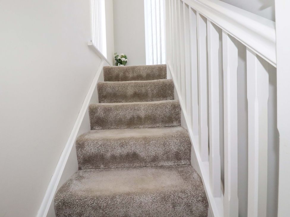 A staircase with carpet and railing at Little Pippin in Carlyon Bay near St Austell