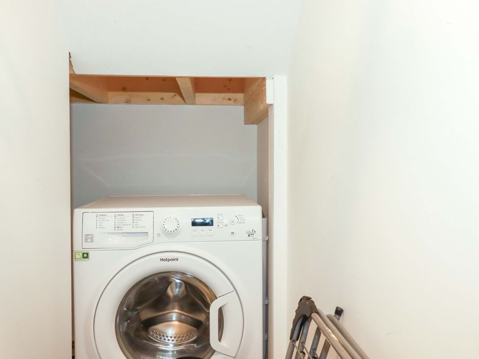 A washing machine in a laundry room at Little Pippin in Carlyon Bay near St Austell
