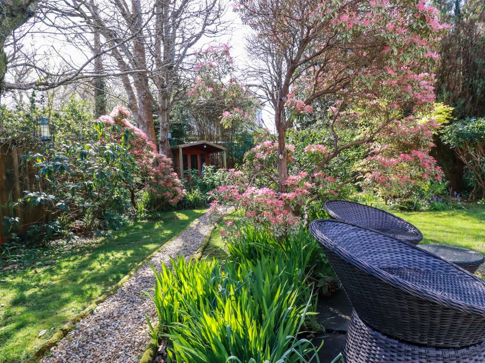A garden with a path and chairs at Little Pippin in Carlyon Bay near St Austell