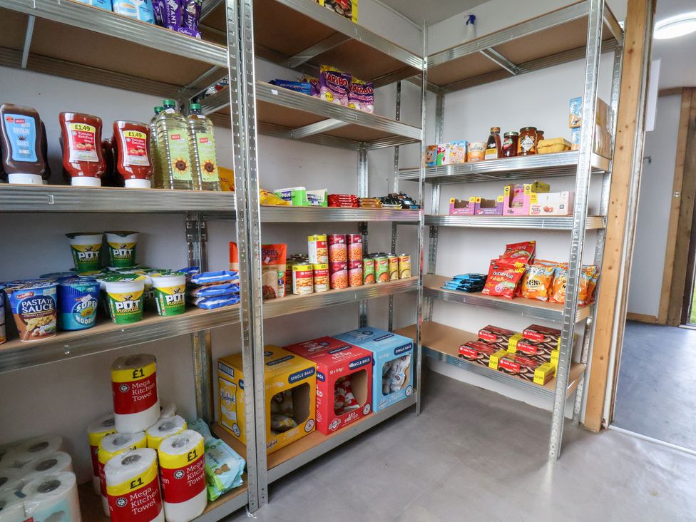 A pantry with shelves filled with various food items at Stable Cottage in Staintondale
