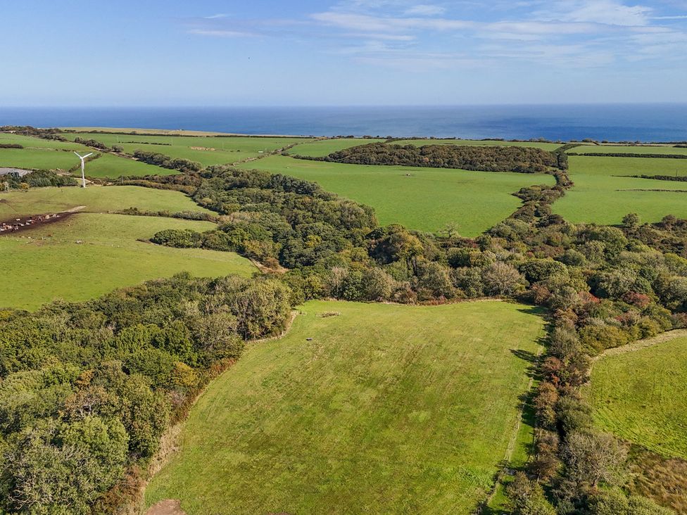 A landscape view featuring fields, trees, and ocean at Stable Cottage in Staintondale
