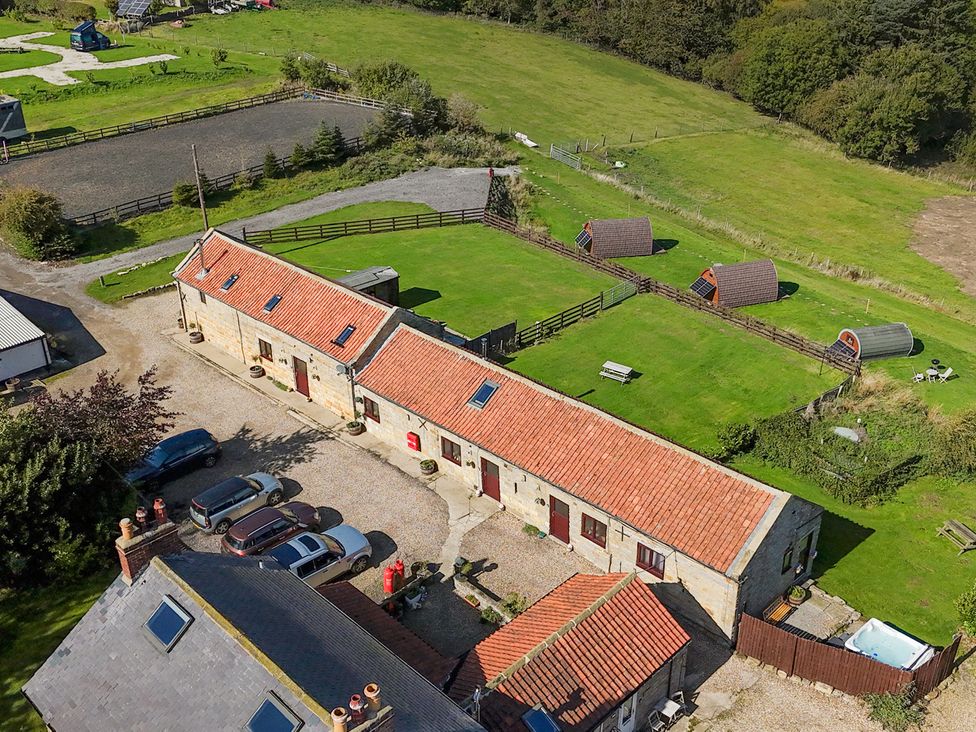An outdoor view of a barn and surrounding grassy areas at Stable Cottage in Staintondale
